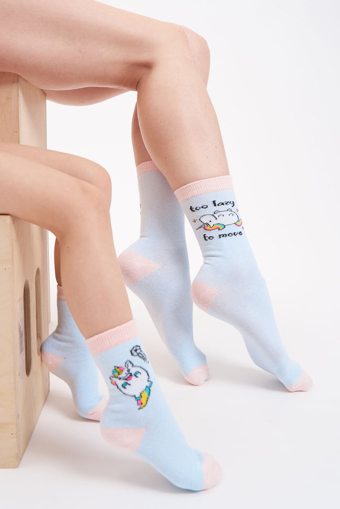 Sky blue women’s socks with a reclined unicorn and text that says “Too Lazy to Move” and kid’s sky blue socks with a happy, peppy unicorn.