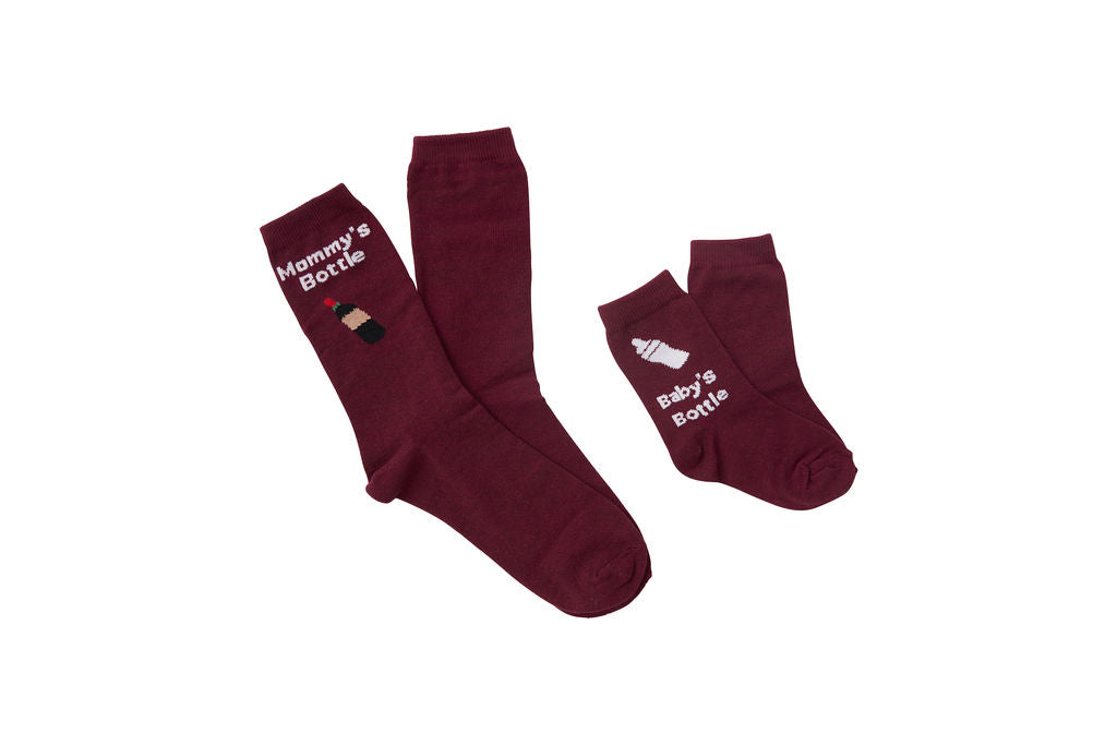 Wine red, women’s socks. Graphic of wine bottle on the adult socks with a graphic of a baby bottle on the kid socks.